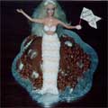 A mermaid sitting on a chocolate sponge covered in real milk chocolate, with Belgian chocolate shells.