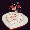 A heart-shaped madeira engagement cake is decorated with a sugar-crafted burst of hearts.