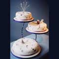 An elegant and modern 3-tier cake decorated with stars and three sugar crafted mice. The bottom tier is a fruit cake, and the top two tiers have a rich chocolate recipe.