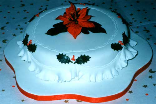 A Christmas cake decorated with a sugar poinsettia.